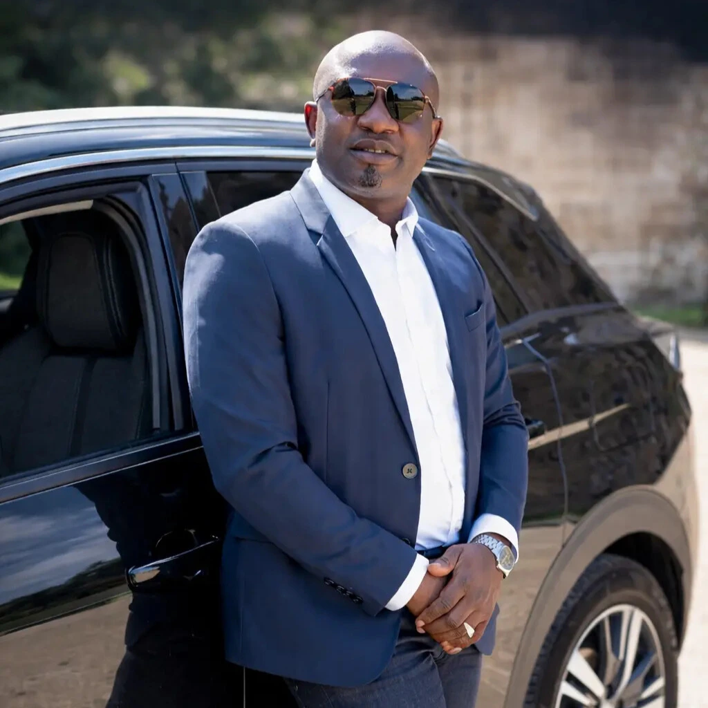 Jacques Mban, chauffeur privé MJ Prestige, devant un véhicule premium
